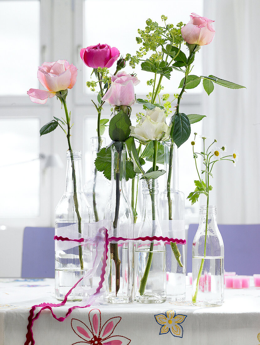 Various bottles with fresh flowers