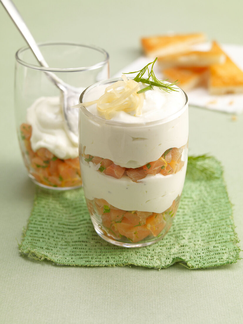 Wasabi mousse with smoked salmon and dill in glass kept on green cloth