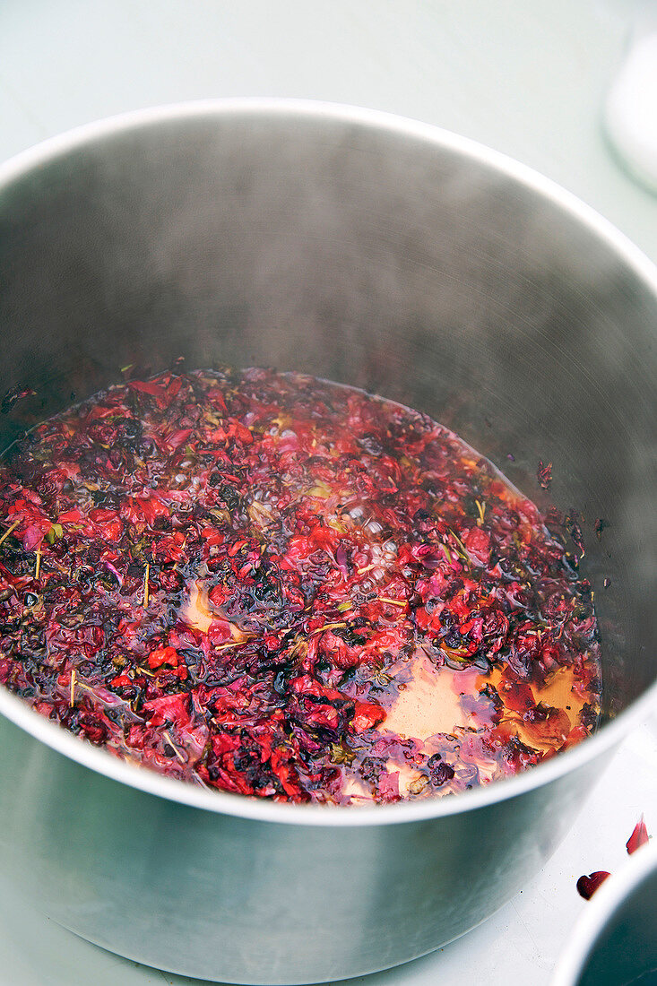 Flower petals being boiled in pot for making geranium colour, step 1