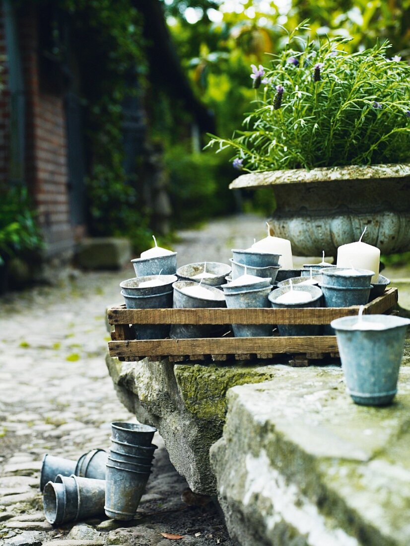 Candles in zinc cups on a stone wall