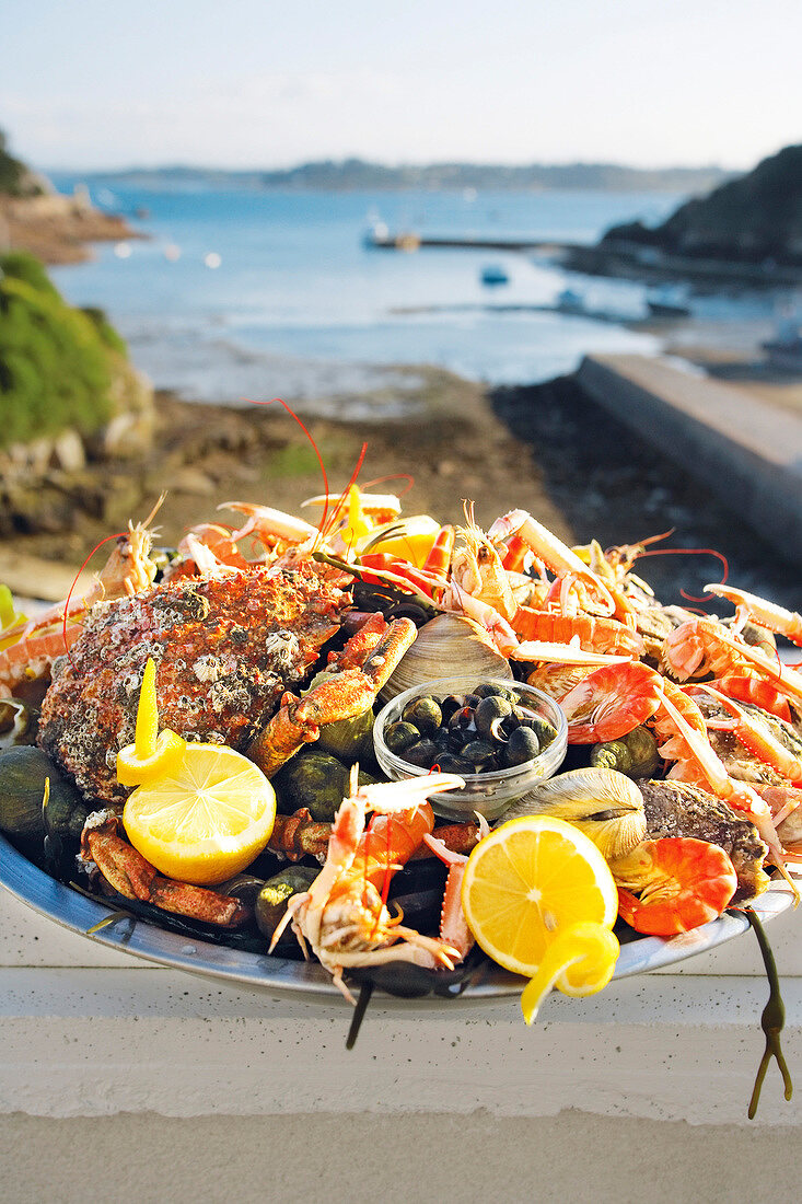Mussels, shrimp, crabs and halved lemons on platter