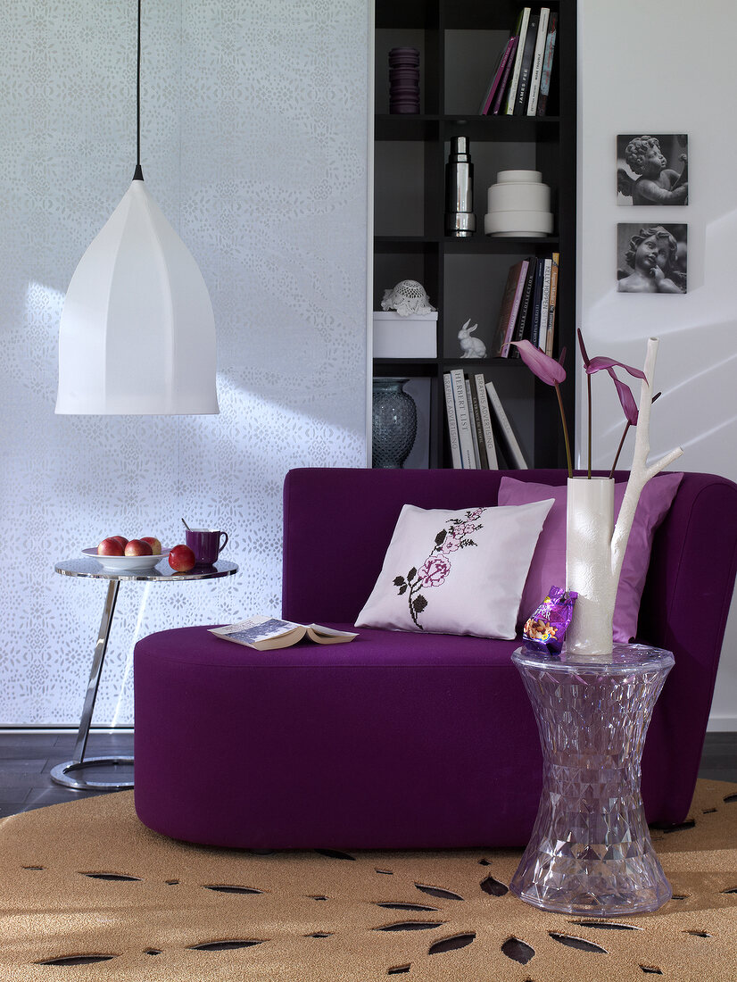 Stylish purple chaise lounge with cushions and cupboard with sliding doors