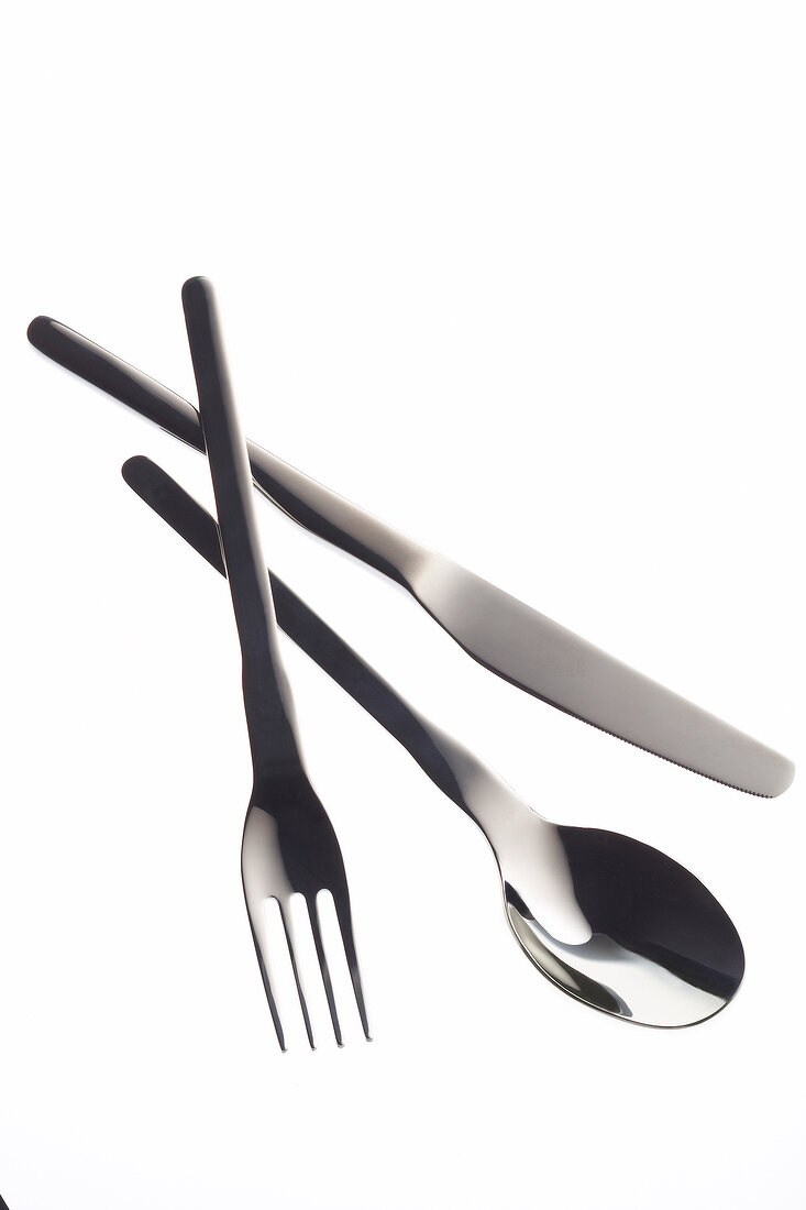 Silver knife, fork and spoon on white background