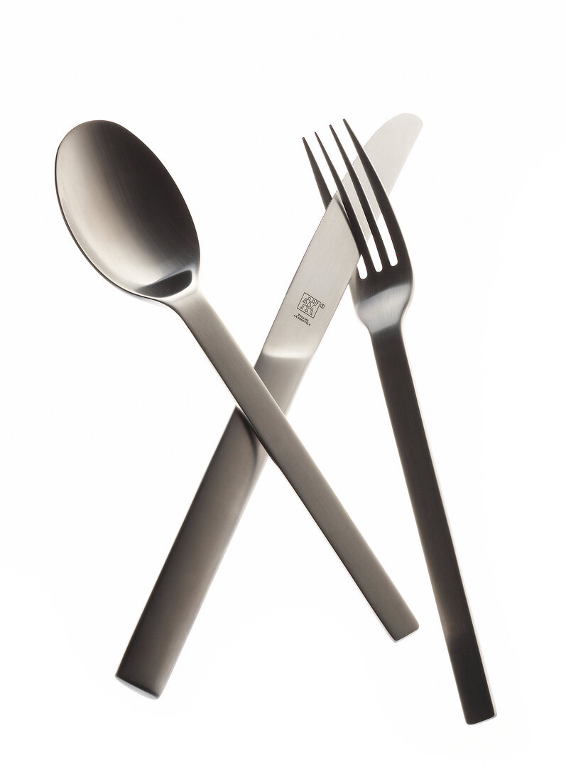 Silver knife, spoon and fork on white background