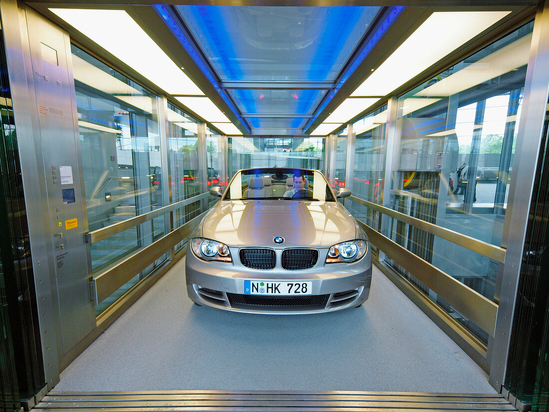 Silver convertible car in glass elevator, BMW World, Munich, Germany