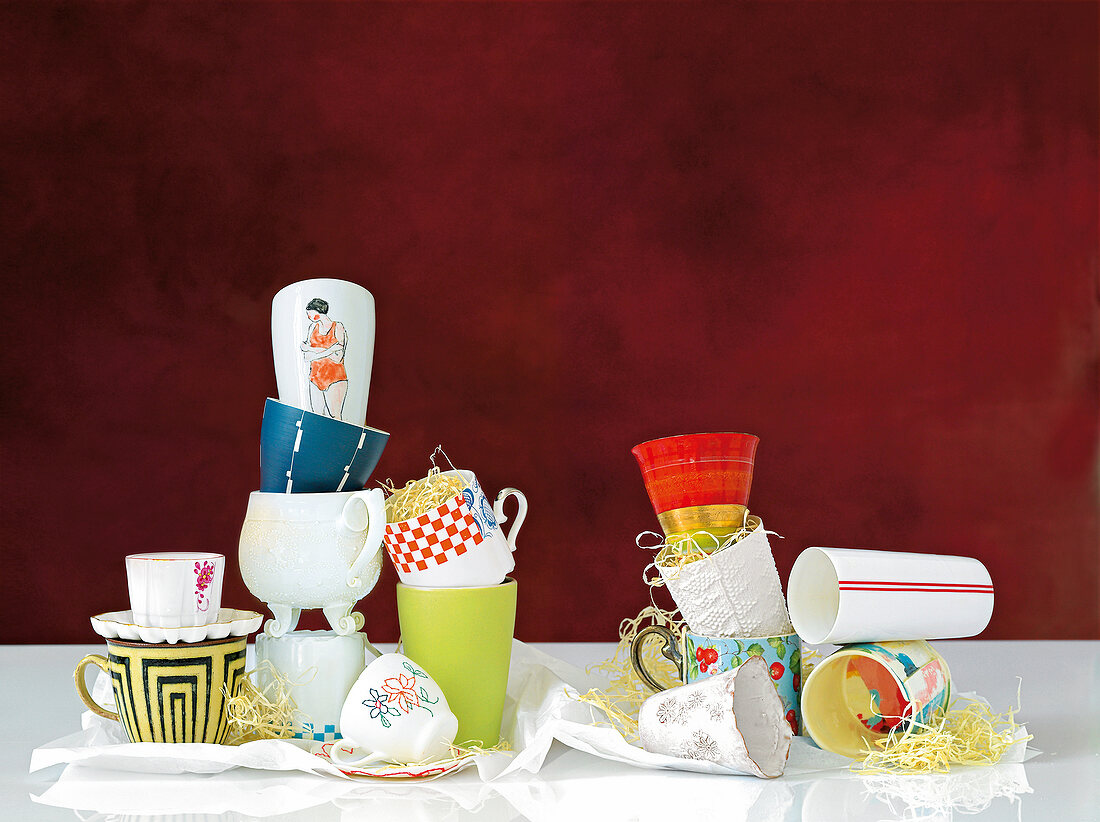 Variety of ceramic cups in front of red background