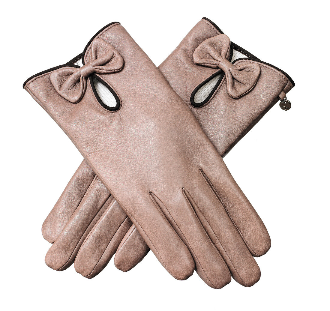 Close-up of beige coloured calf leather gloves on white background