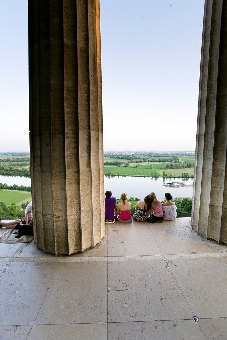 People sitting at Plateau Doric columns in The Walhalla against Danube river, Germany