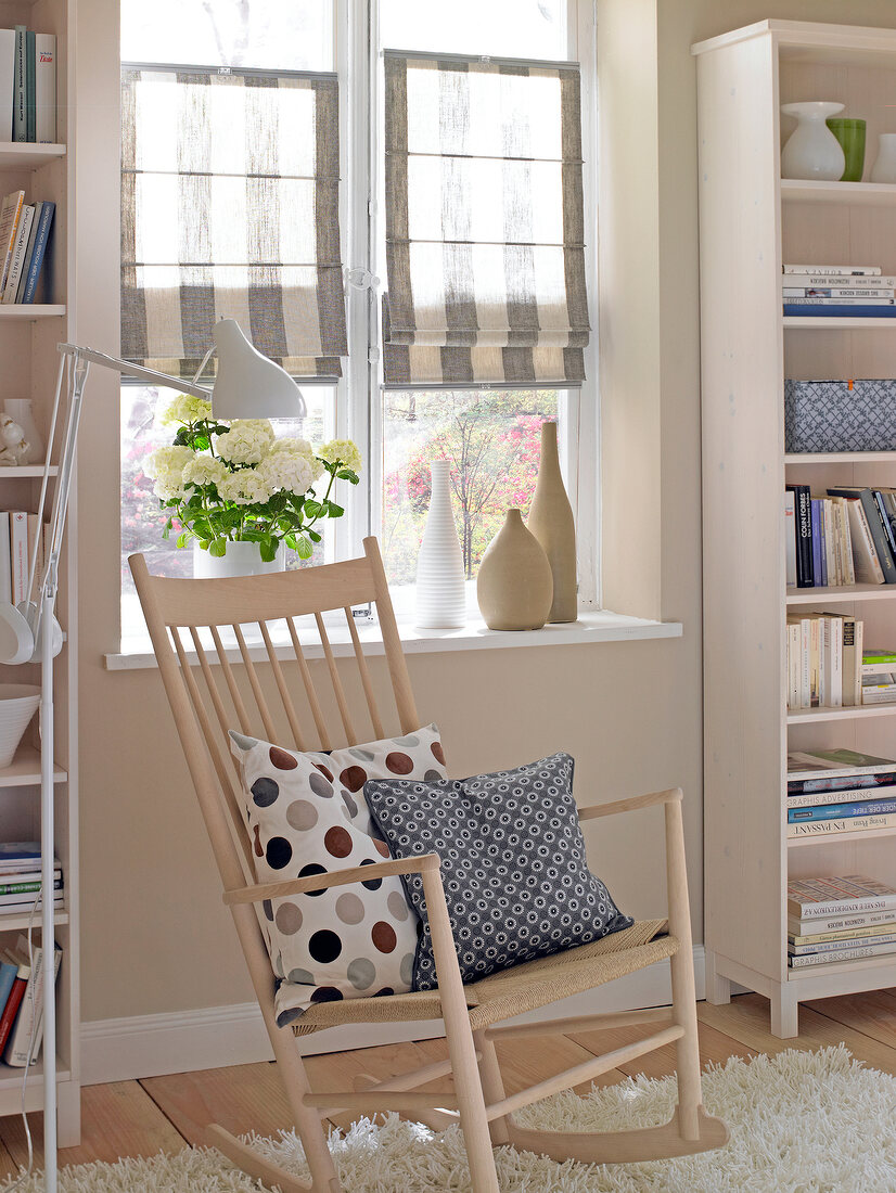 Living room with rocking chair in front of roman blinds on window