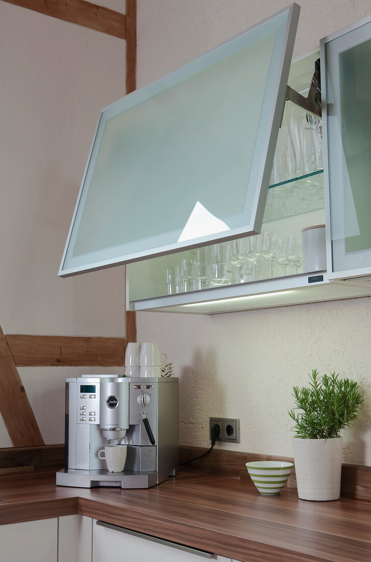 Close-up of wall cabinet with glass door opening upwards