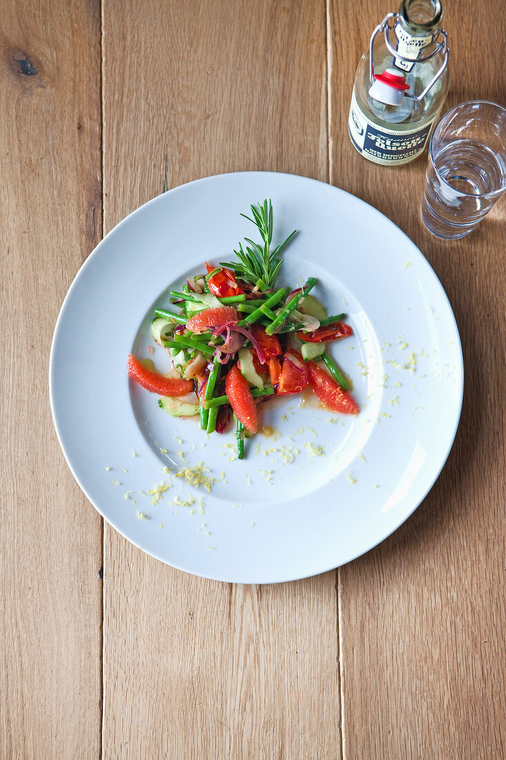 Warm bean salad with grapefruit and rosemary on plate, overhead view