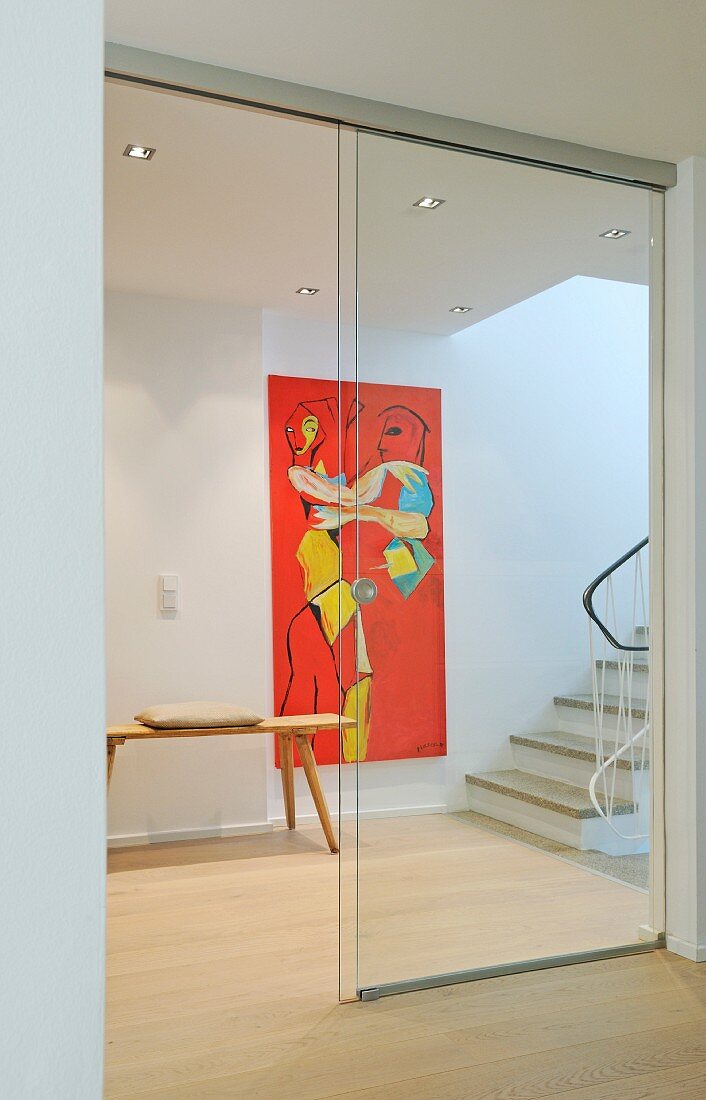Hallway with staircase, artwork on wall and sliding glass door