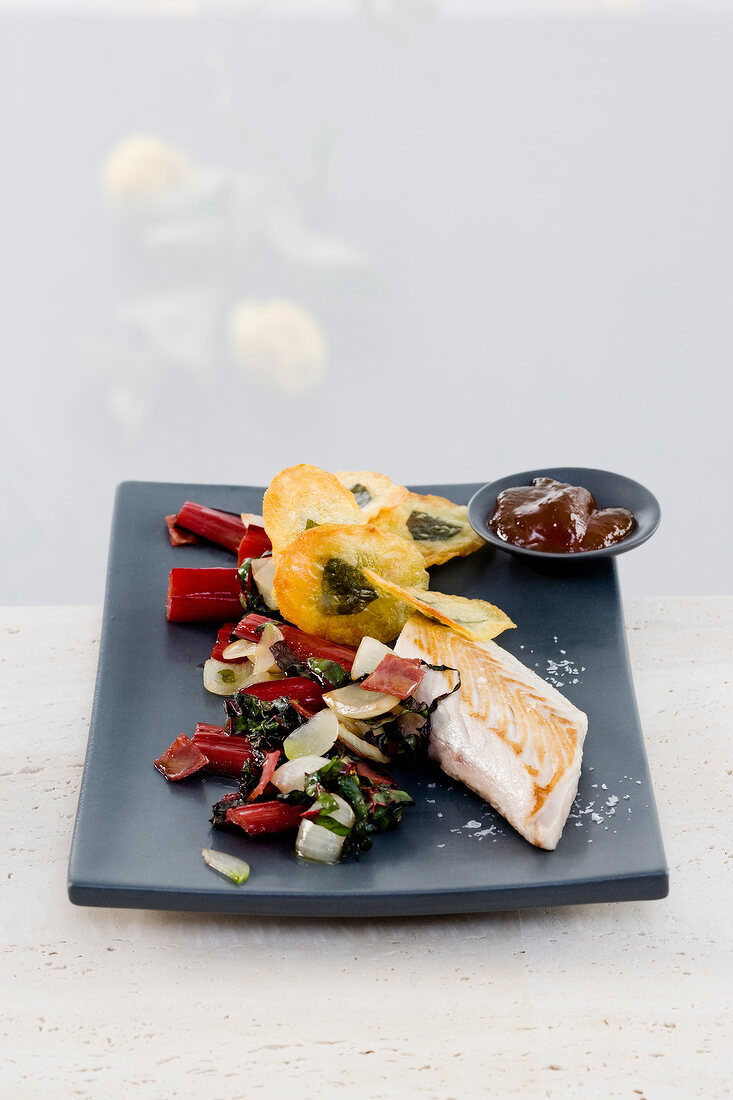 Mahi Mahi with quince jelly chard and potato chips on plate