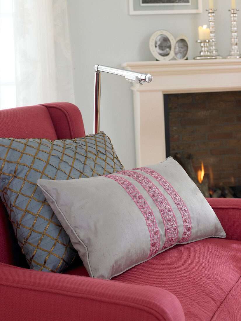 Close-up of red arm chair with two gray silk cushions