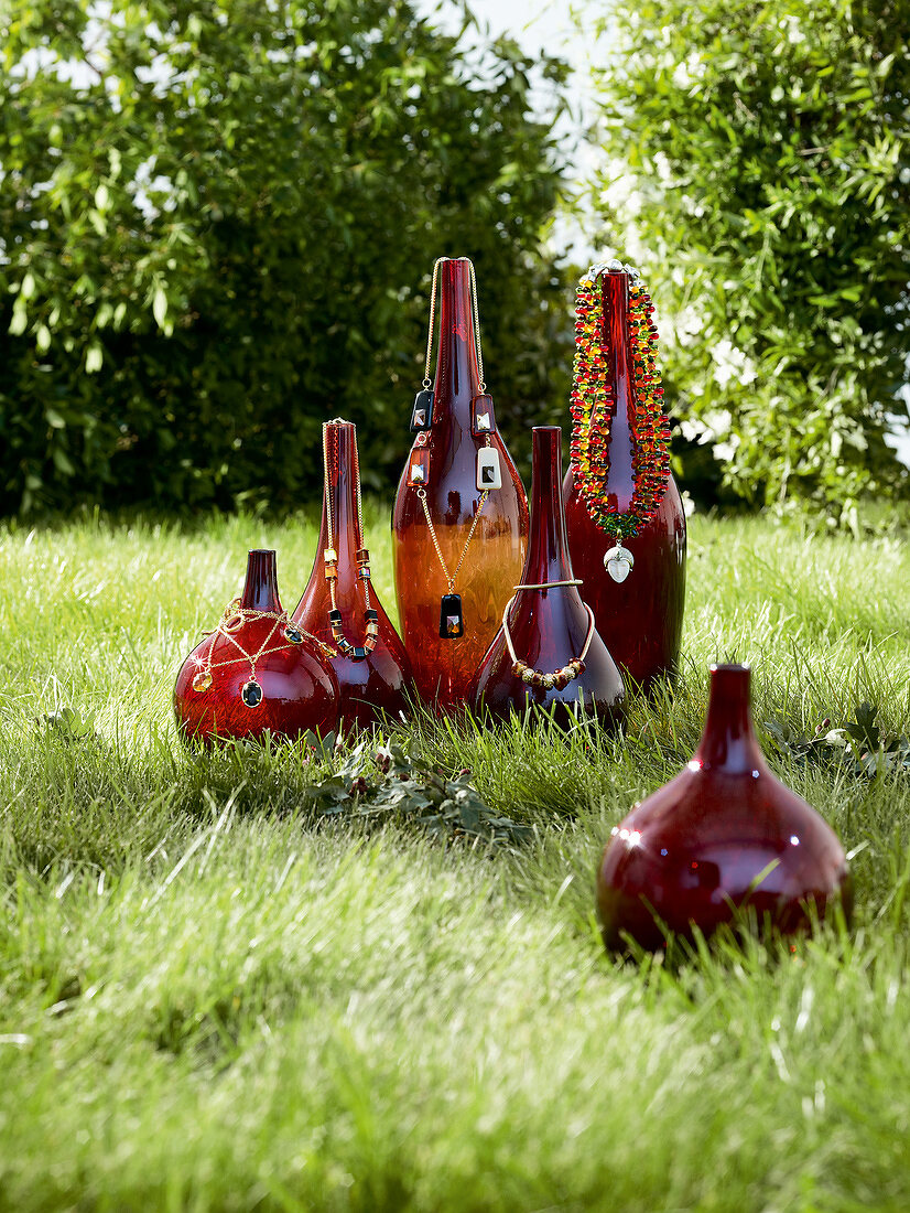 Necklaces arranged on vases in meadow