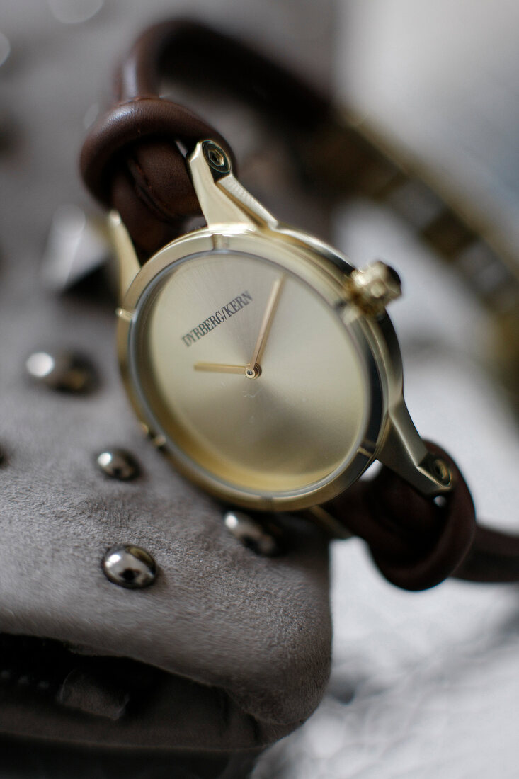 Close-up of gold ladies watch with leather strap