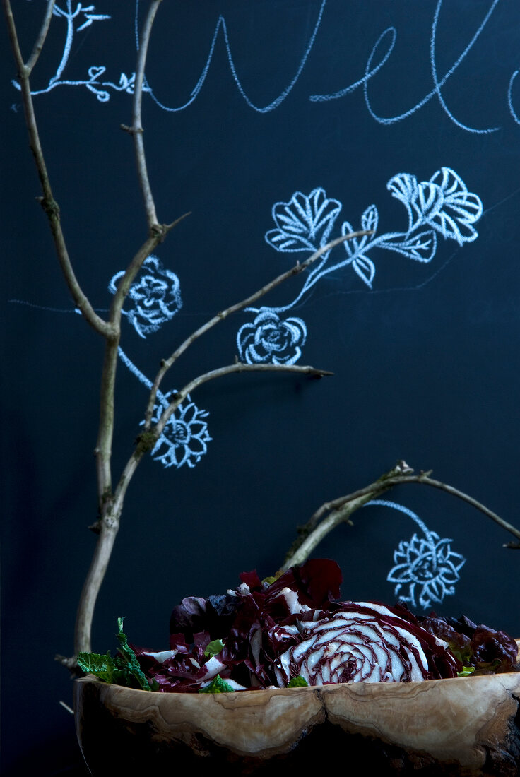 Branches in front of dark blue wallpaper with floral pattern