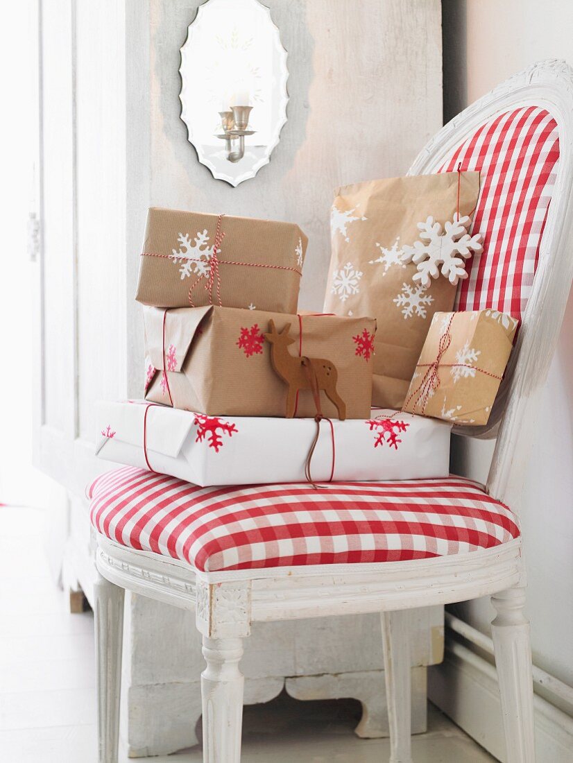 Wrapped Christmas presents on an upholstered chair with a red and white checked cover