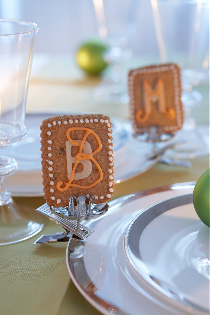 Table decorated with silver plate candle holder and biscuits with initials