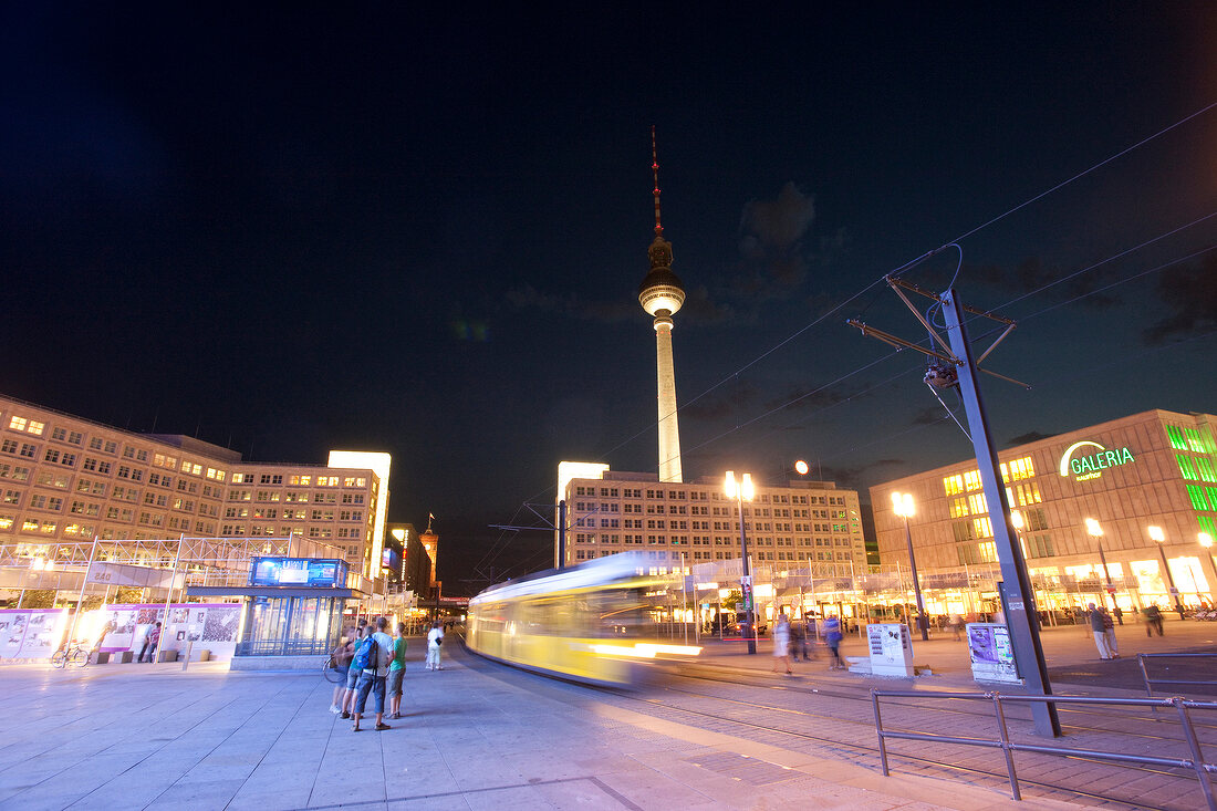 Berlin: Alexanderplatz, abends, Straßenbahn, Menschen, unscharf.