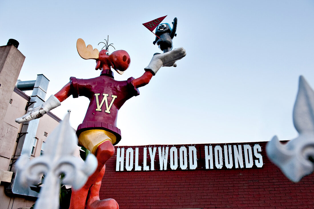 Low angle view of Boulevard Hollywood hotel and Dogs Hounds figure, Los Angeles, USA