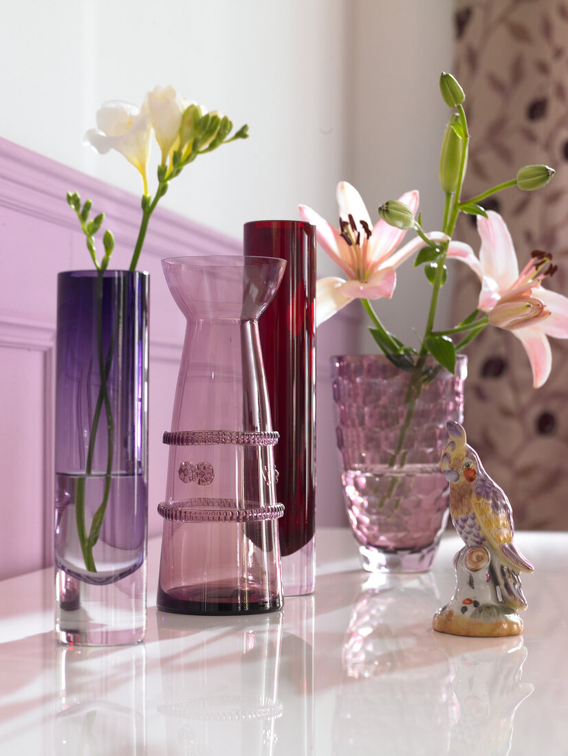Close-up of various purple vases with flowers