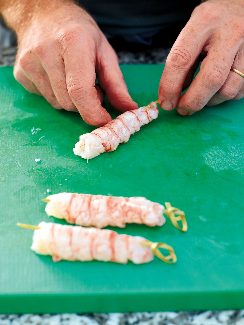 Close-up of putting langoustines on a skewer