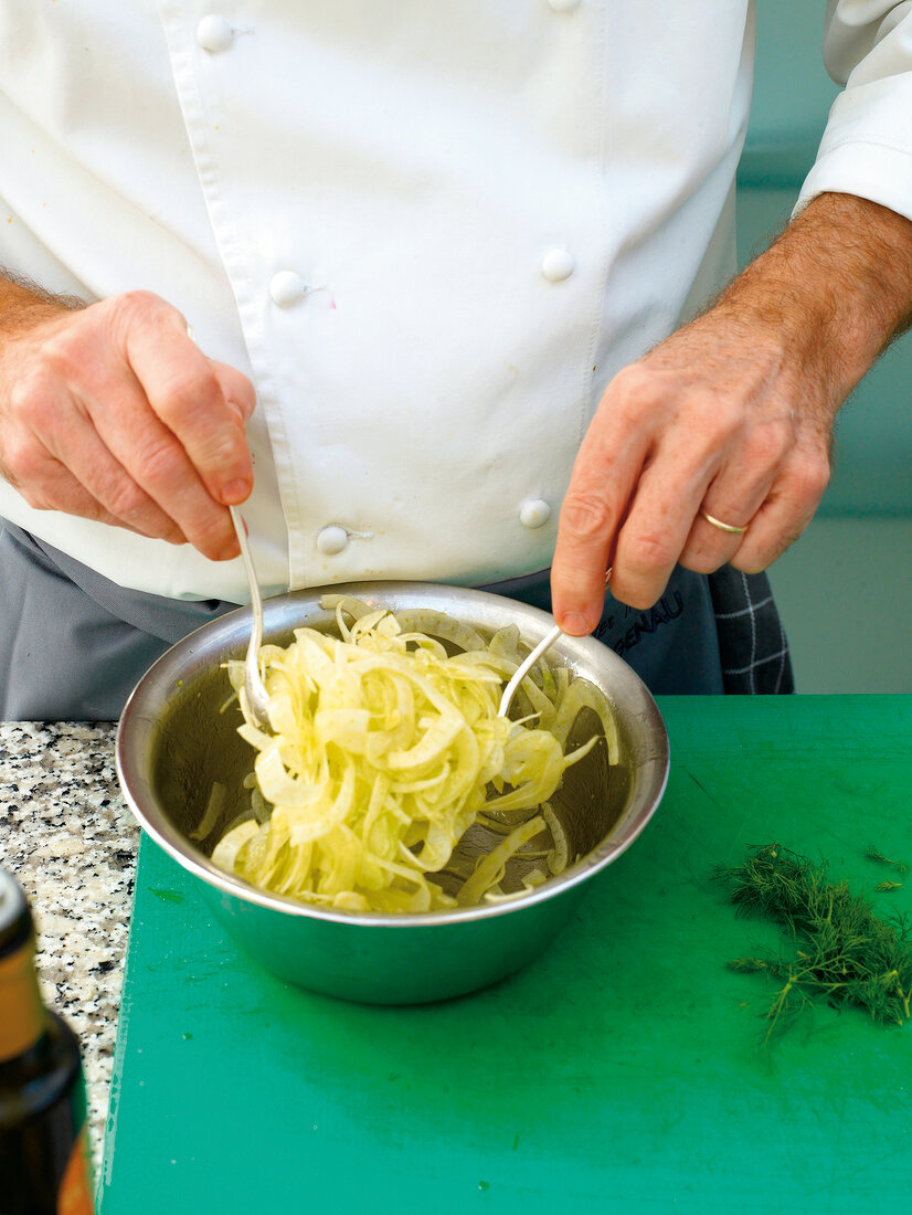 Close-up of mixing the oil and fennel in a bowl
