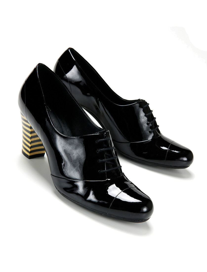 Paint black pumps in gent style with striped Cuban heels on white background