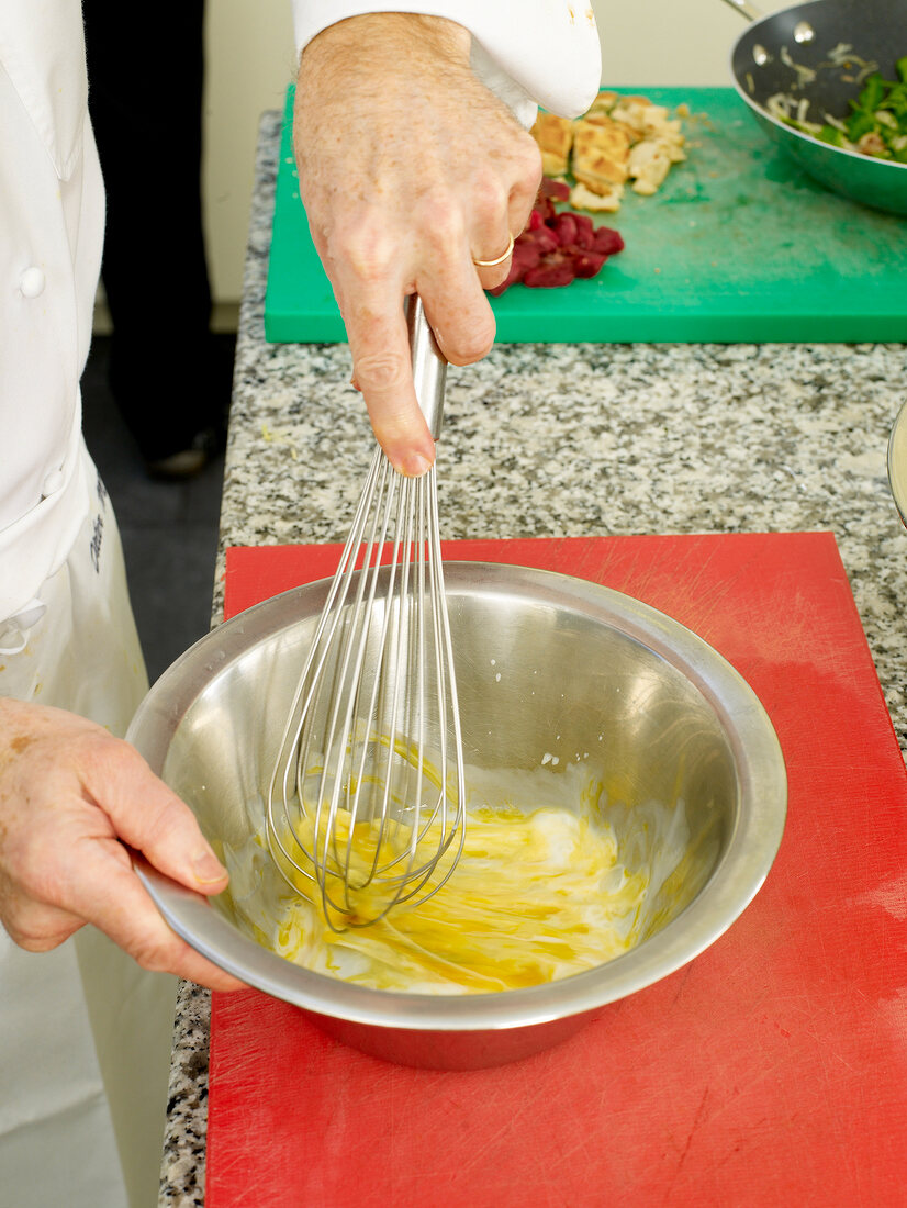 Close-up of man's hands whisking ingredients in bowl