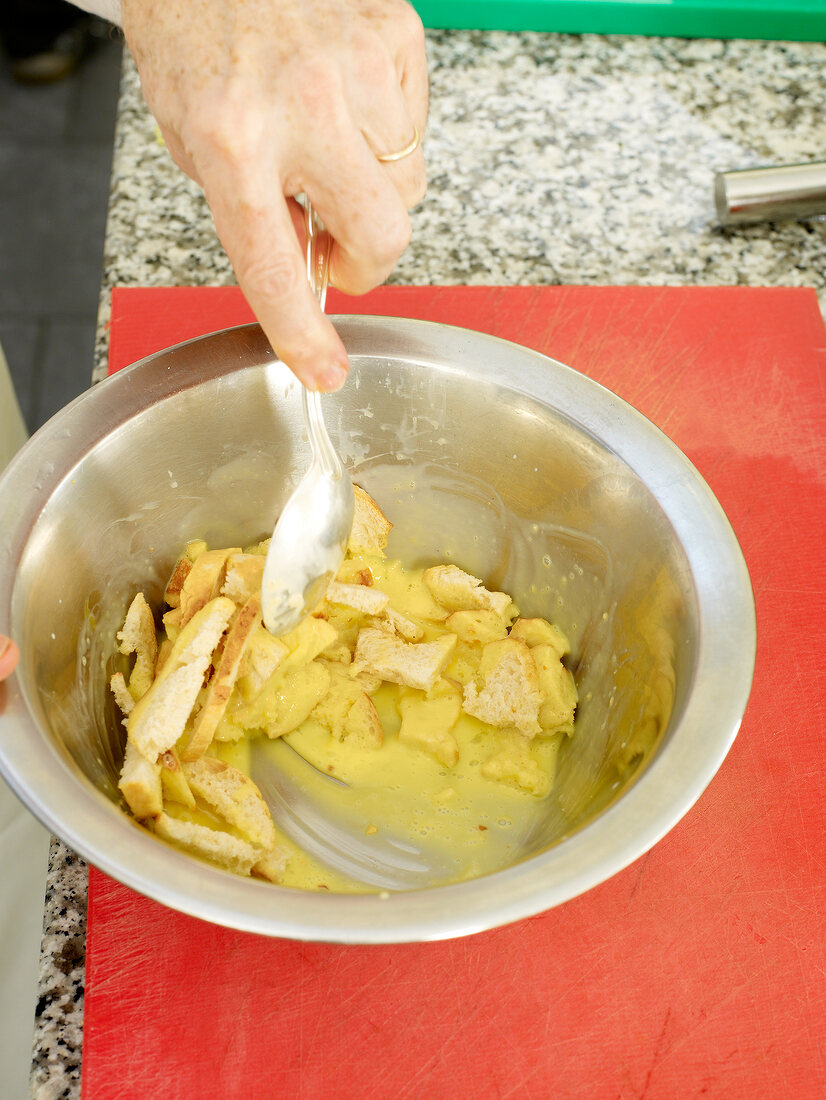 Close-up of man's hand mixing ingredients with spoon in bowl