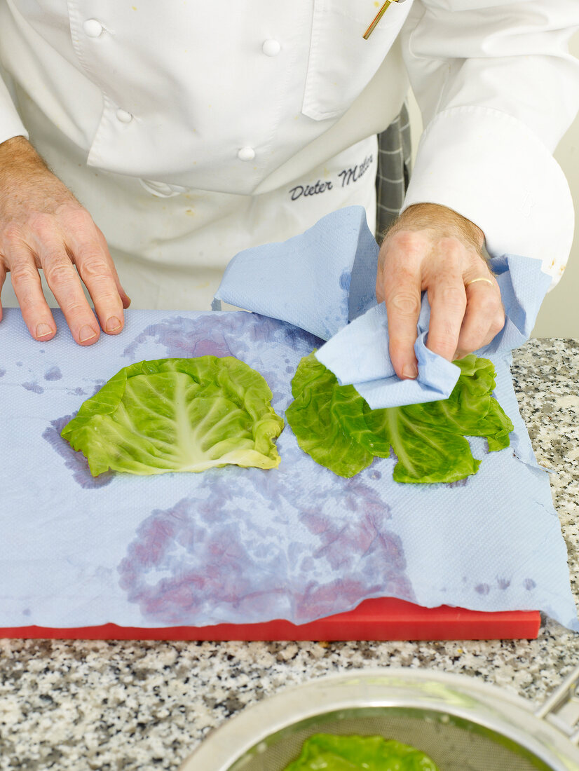 Man's hand pat drying cabbage leaves