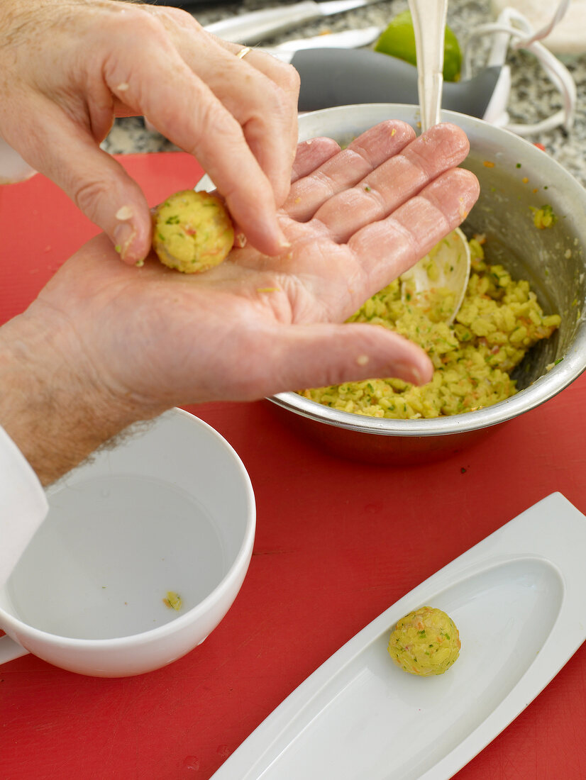 Close-up of man's hands making balls from fried rice