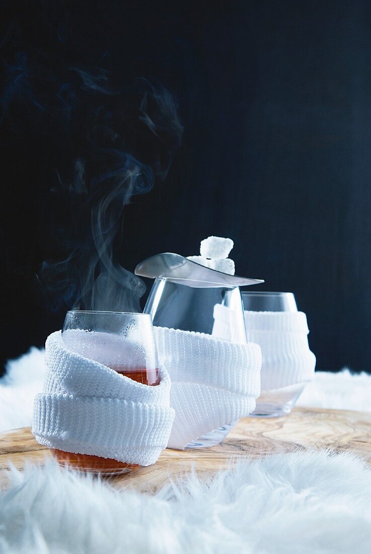 Three glasses of hot punch wrapped in sweatbands