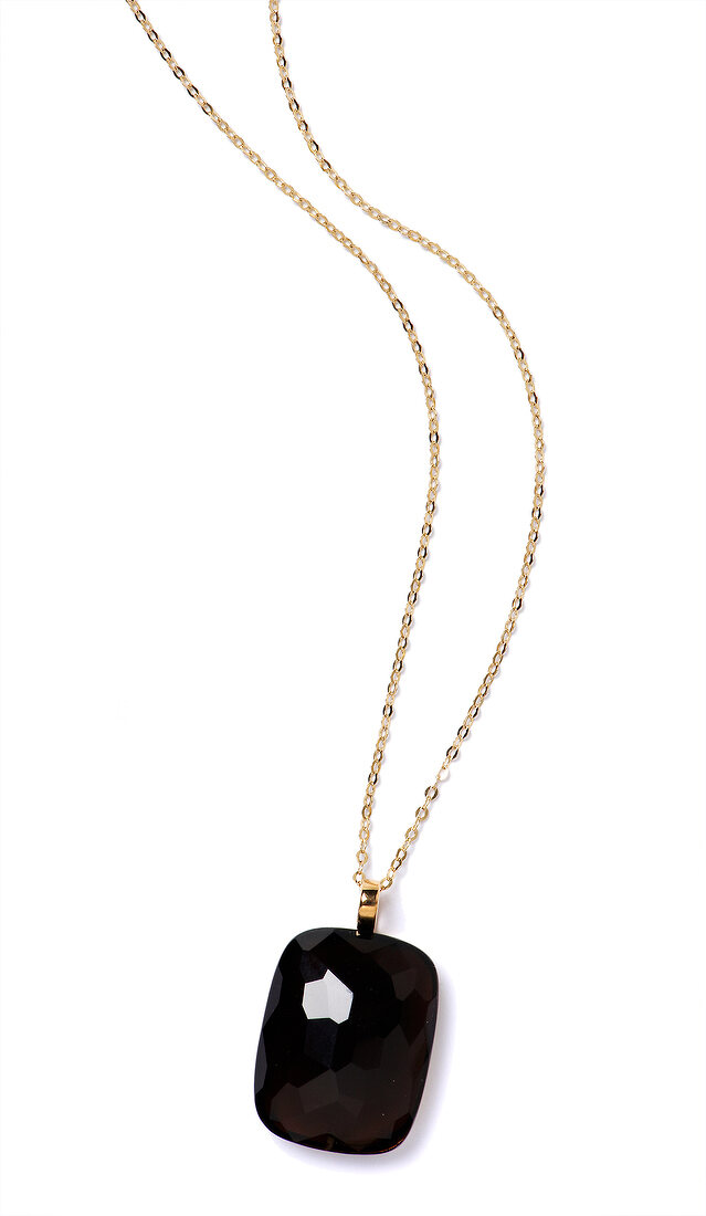 Gold necklace with black smoky quartz pendant on white background
