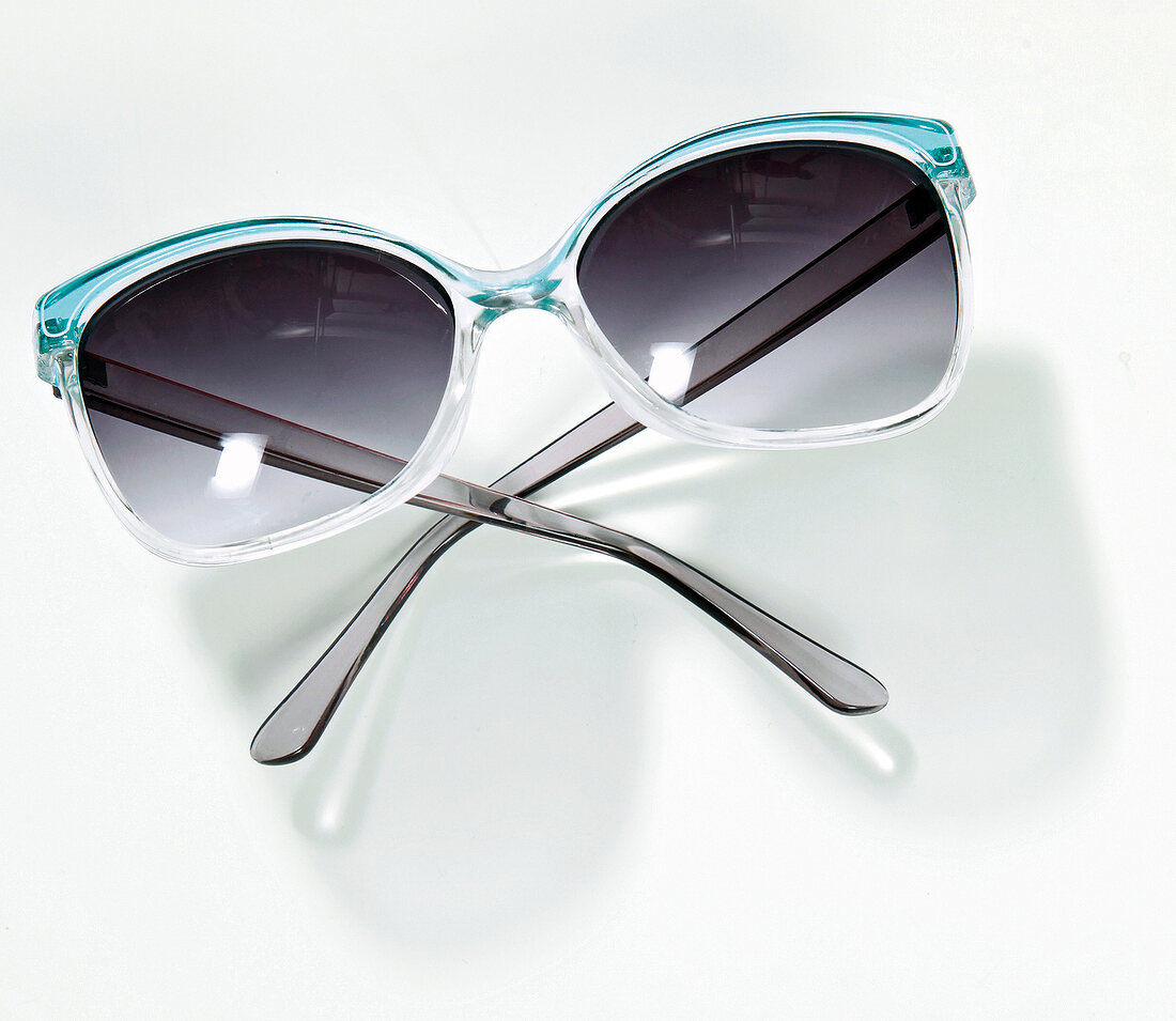 Turquoise coloured sunglasses on white background