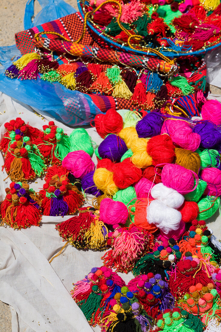 Multi-coloured roll of wool with multi-coloured decorative material