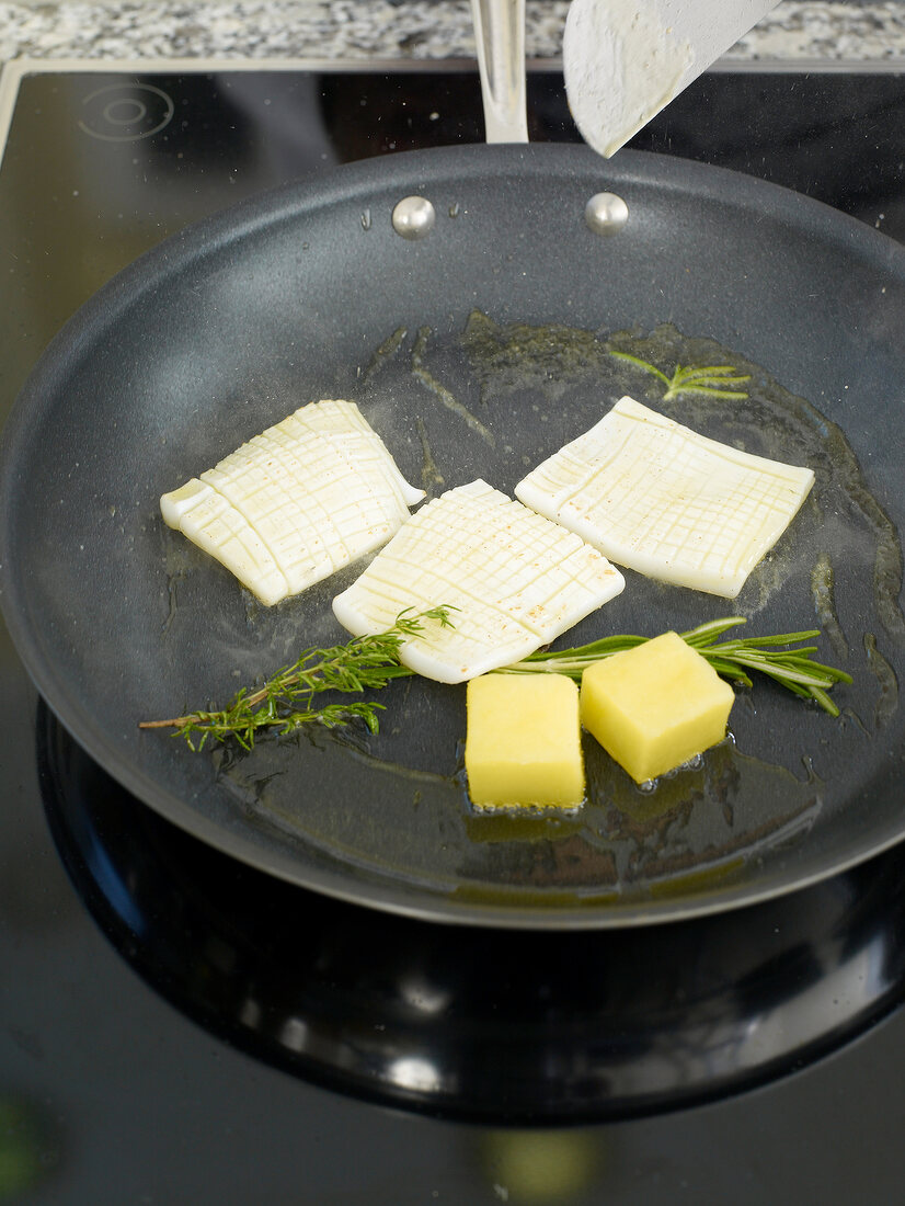 Leek, potatoes and other ingredients being stir fried in pan