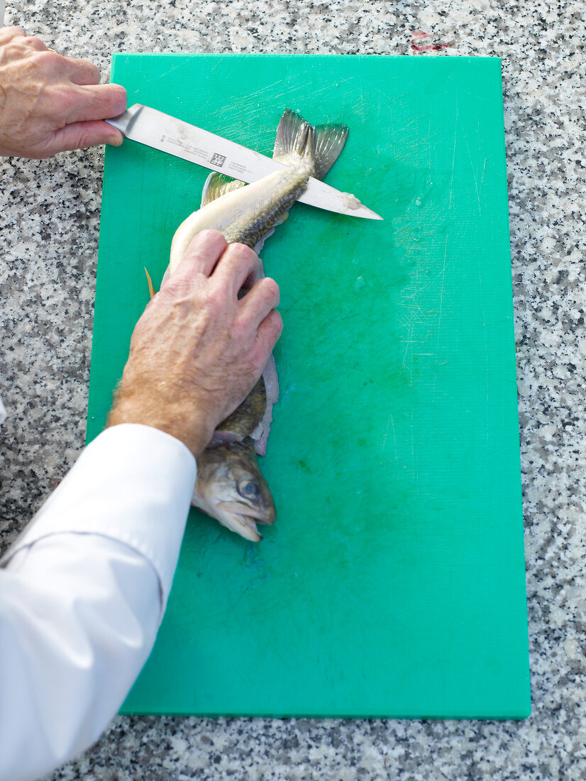 Filleting char with knife on board