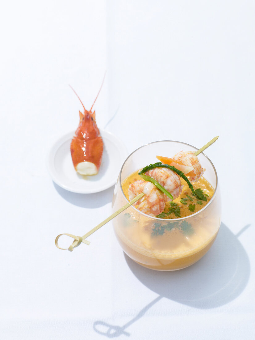 Crayfish bisque in bowl and crayfish's head on plate on white background