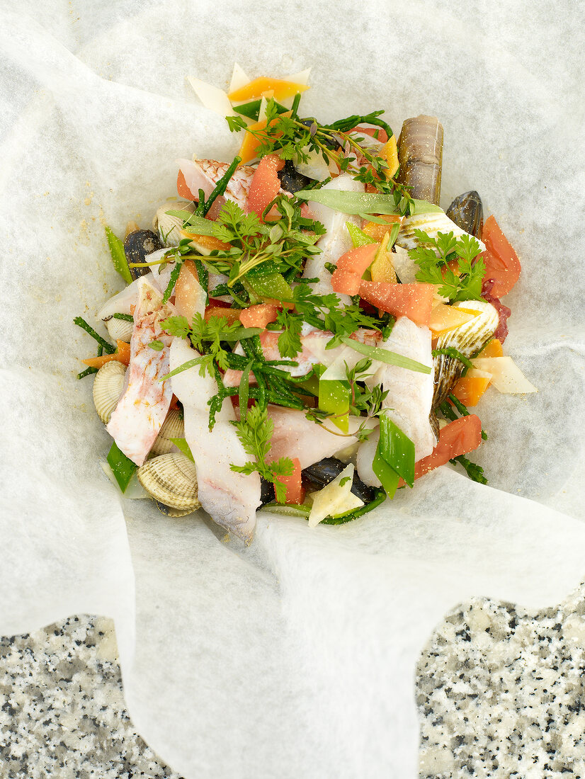 Seafood with vegetables on parchment paper
