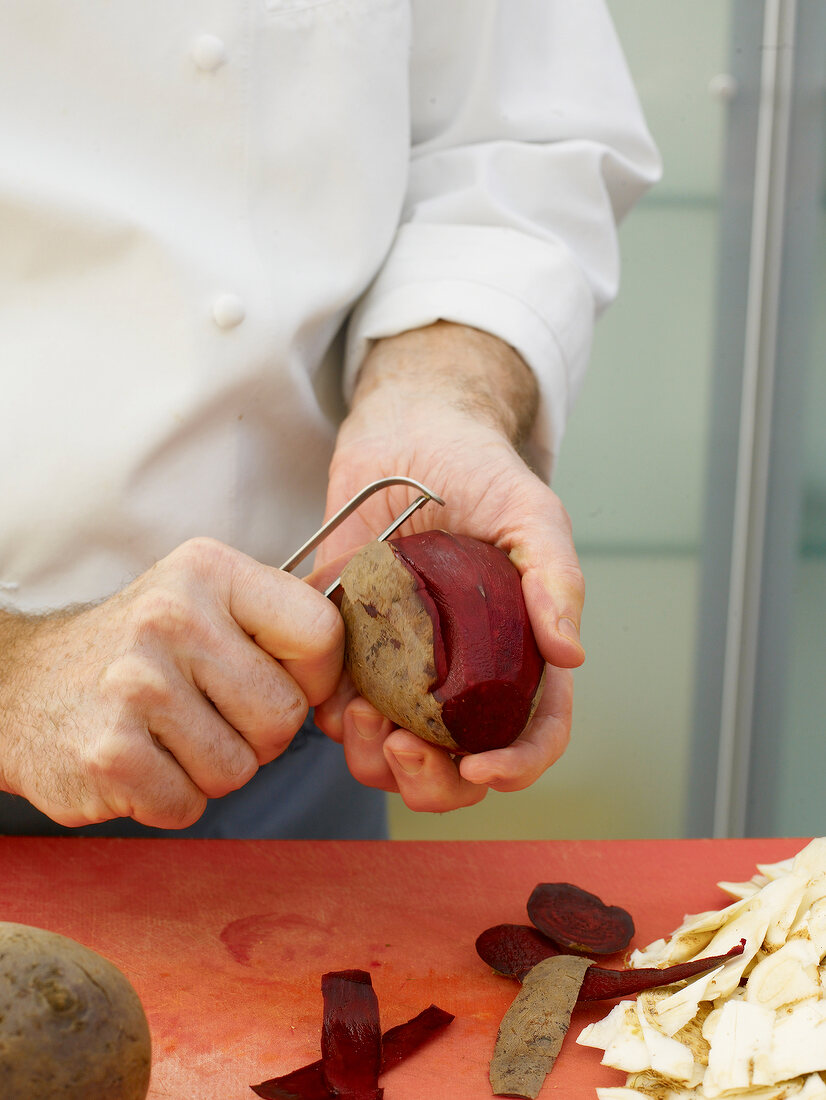 Chef peeling beetroot for preparing beetroot puree