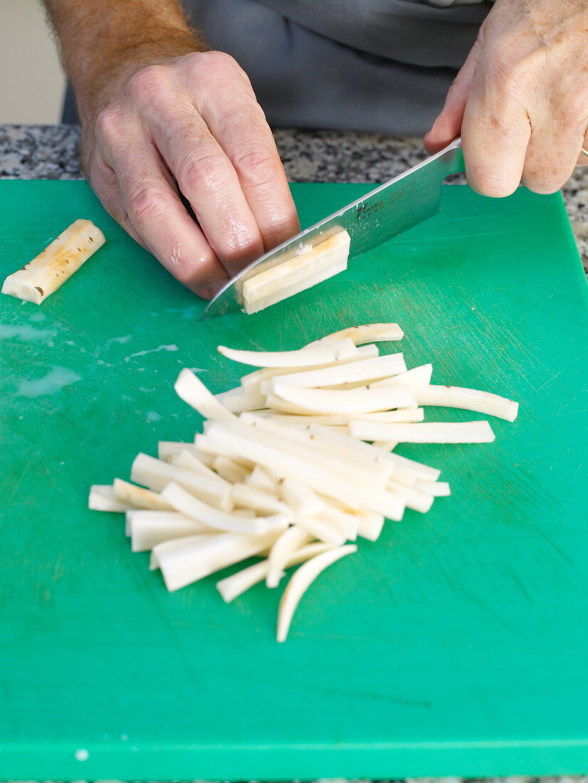 Salsify being sliced on cutting board