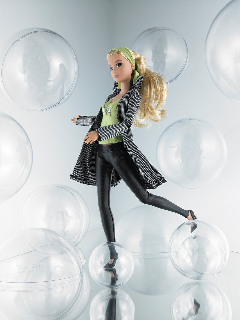 Barbie doll in checked jacket over green top and leather leggings on bubble background