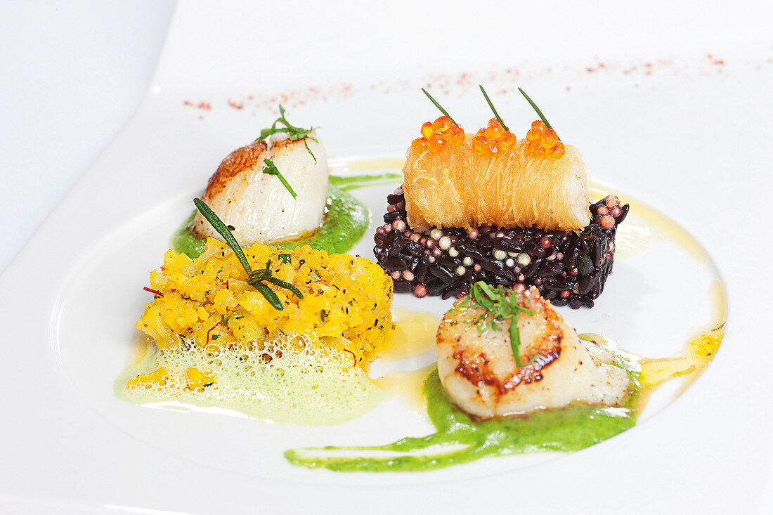 Scallops with risotto, tapioca, chive and hollandaise sauce on plate