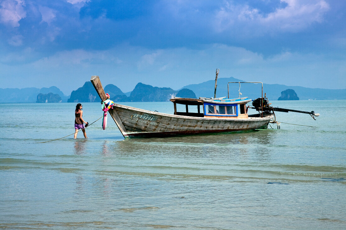 Thailand: einsame Insel, Meer, Fischerboot, Frau im Wasser, Idyll