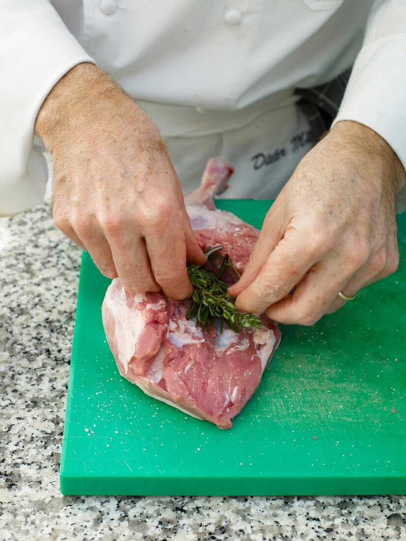 Chef stuffing lamb's leg