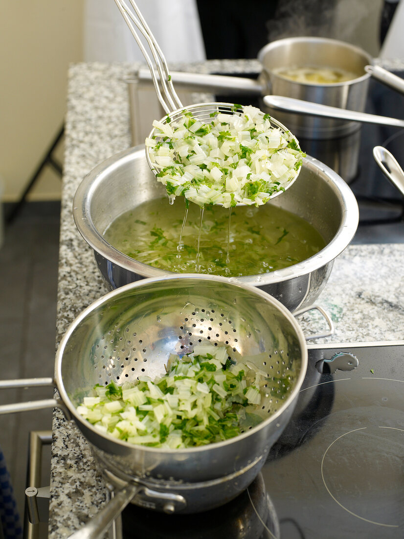 Turnip green being strained from water