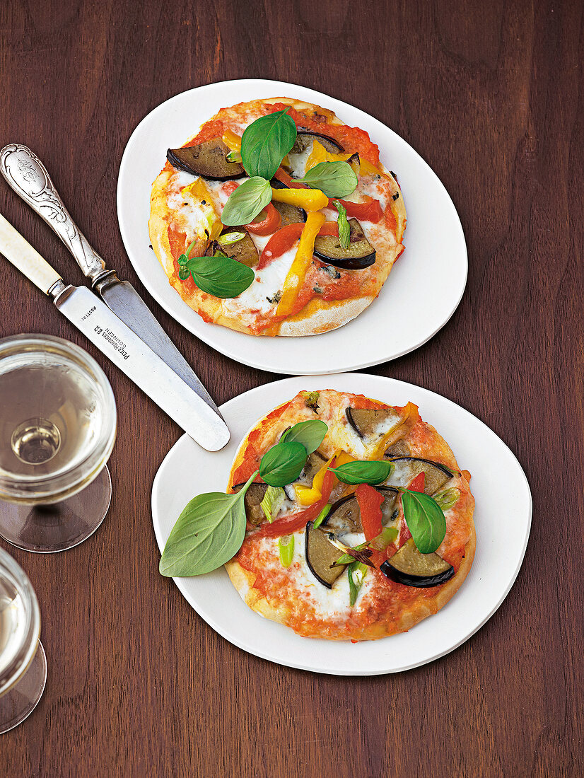 Two aubergine pizzas with peppers, blue cheese and mozzarella