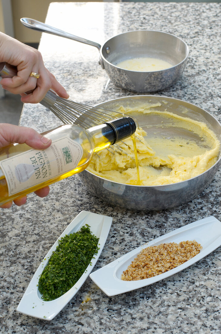 Pouring pinenut oil in mashed potatoes